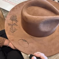 "Oakley" - a gorgeous brown, hand burned hat with flowers.